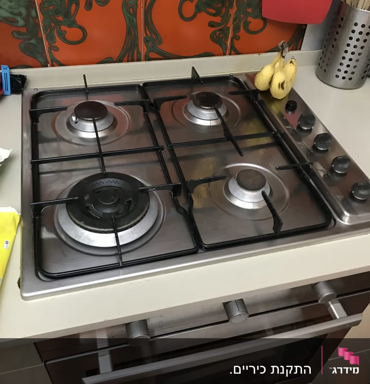 כיריים גז עם ארבעה מבערים וכפתורי שליטה